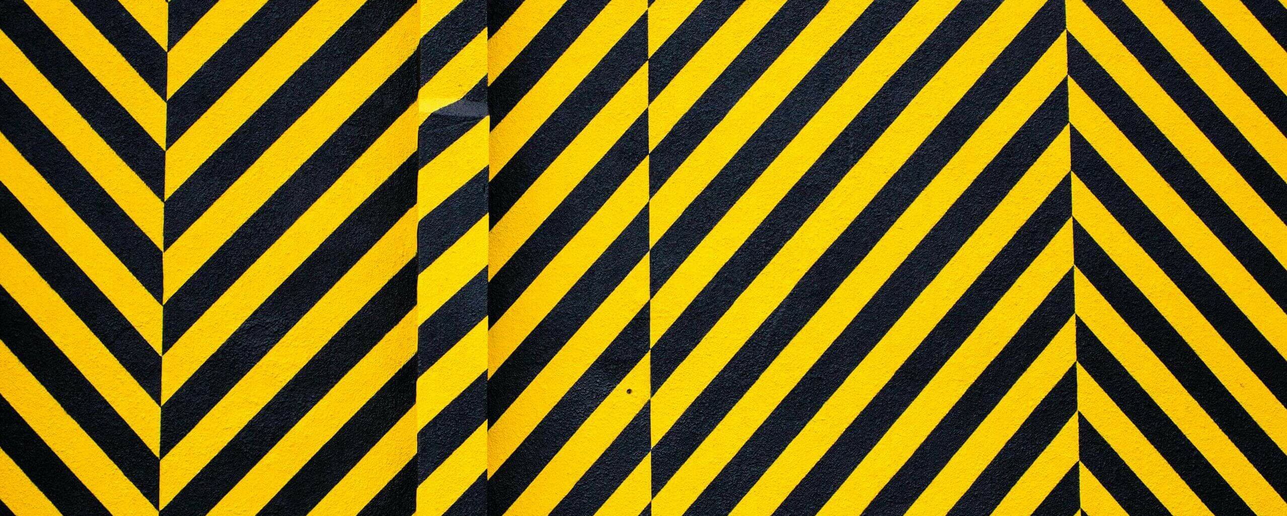 Dynamic yellow and black patterned background with bold diagonal stripes for creative design use.